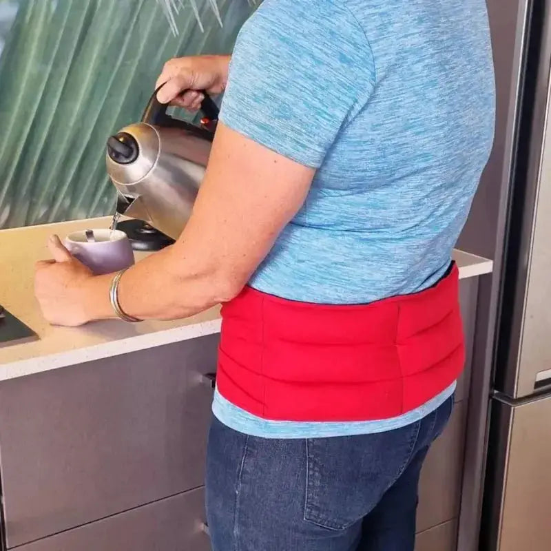 Lady wearing a waist wheat bag while making a cuppa