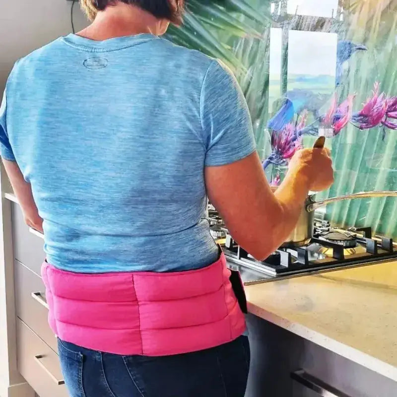 Woman wearing a wrap around wheat bag for lower back pain relief