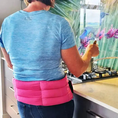 Woman wearing a wrap around wheat bag for lower back pain relief